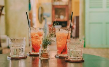 Top 5 cocktailuri răcoritoare și cum le prepari acasă Vara este anotimpul ieșirilor cu prietenii. Însă uneori ai prefera să te vezi cu ei la tine acasă. Dacă ești un bun organizator, poți transforma o întâlnire cu ei într-o petrecere reușită. Alteori, simți nevoia să te relaxezi în singurătate sau alături de partener ori parteneră, pentru a-ți reîncărca bateriile și a te bucura de intimitate. Indiferent de situație, căldura verii trebuie combătută cu o băutură răcoritoare, care alungă moleșeala. Cocktailurile sunt perfecte vara, pentru că nu au conținut mare de alcool și combină sucuri sau siropuri de fructe cu gheață. Chiar dacă poți cumpăra unele cocktailuri în sticle sigilate, cele mai bune sunt cele făcute imediat înainte de servire. De aceea, ți-am pregătit o listă cu cele mai bune rețete de cocktailuri răcoritoare pe care le poți prepara acasă. Pink gin spritz Ingrediente Cocktailurile cu gin sunt răcoritoare și tonice. Comandă aici gin și prepară un pink gin spritz delicios. Ai nevoie de următoarele ingrediente: gheață; 50 ml de gin cu aromă de trandafir; 35 ml lichior de lici; apă carbogazoasă. Mod de preparare Umple un pahar de tip highball cu gheață. Pune ginul și lichiorul, apoi adaugă apa minerală și savurează-l. Sea Breeze Ingrediente Pentru a pregăti acest cocktail celebru ai nevoie de: 50 ml de vodka; 100 ml de suc de merișoare; 50 ml de suc de grepfruit; gheață; 1 felie subțire de lămâie. Mod de preparare Umple un pahar înalt cu gheață și adaugă vodka, sucul de merișoare și sucul de grepfruit. Amestecă încet până când exteriorul paharului se simte rece și adaugă felia de lămâie. Tequila Sunrise Ingrediente Tequila Sunrise este un cocktail clasic, colorat și cu umbreluță. Ingredientele necesare pentru prepararea sa sunt: 2 lingurițe de grenadină; gheață; 50 ml de tequila; 1 lingură de triplu sec; sucul de la 1 portocală mare sau 2 mici; sucul unei jumătăți de lămâie; 1 cireașă de cocktail. Mod de preparare Toarnă grenadina într-un pahar înalt și pune-l deoparte. Umple un shaker cu gheață și adaugă tequila, triplu suc și sucurile de lămâie. Amestecă bine, până când exteriorul shakerului se simte rece. Adaugă câteva cuburi de gheață în paharul de servire. Filtrează de 2 ori cocktailul în el, încercând să nu agiți prea mult stratul de grenadină. Mai adaugă gheață, dacă este nevoie, și decorează cu umbreluța și cireașa. Strawberry Gin Ingrediente Un cocktail simplu, dar gustos și răcoritor, Strawberry Gin se face din: 700 m de gin; 400 g de căpșuni feliate; 100 g de zahăr. Mod de preparare Amestecă ginul cu căpșunile și zahărul într-un vas de 1,5 l și toarnă cocktailul obținut într-un borcan cu sistem de închidere ermetică sau alt recipient care se poate închide bine. Pune-l la frigider și amestecă la fiecare 2 zile, timp de 3 săptămâni. Filtrează-l apoi și servește-l cu gheață. Daiquiri cu pepene roșu Ingrediente Un cocktail cu pepene roșu este emblematic pentru anotimpul cald. Daiquiri-ul pe care ți-l prezentăm necesită: gheață; 50 ml de rom alb; 25 ml de lichior de pepene sau de băutură spirtoasă cu aromă de pepene; 10 m de suc de lime; 100 g de pepene roșu și o felie tăiată sub formă de triunghi pentru servire. Mod de preparare Pune o mână de gheață în blender alături de rom, lichior de pepene roșu, suc de lime și miez de pepene. Folosește blenderul până obții un lichid fin. Umple un pahar hurricane sau alt tip de pahar înalt cu cuburi de gheață și toarnă daiquiri-ul peste ele. Decorează cu felia de pepene. Cele 5 cocktailuri de mai sus sunt răcoritoare și gustoase. Dacă le prepari acasă, alege ingrediente de calitate.